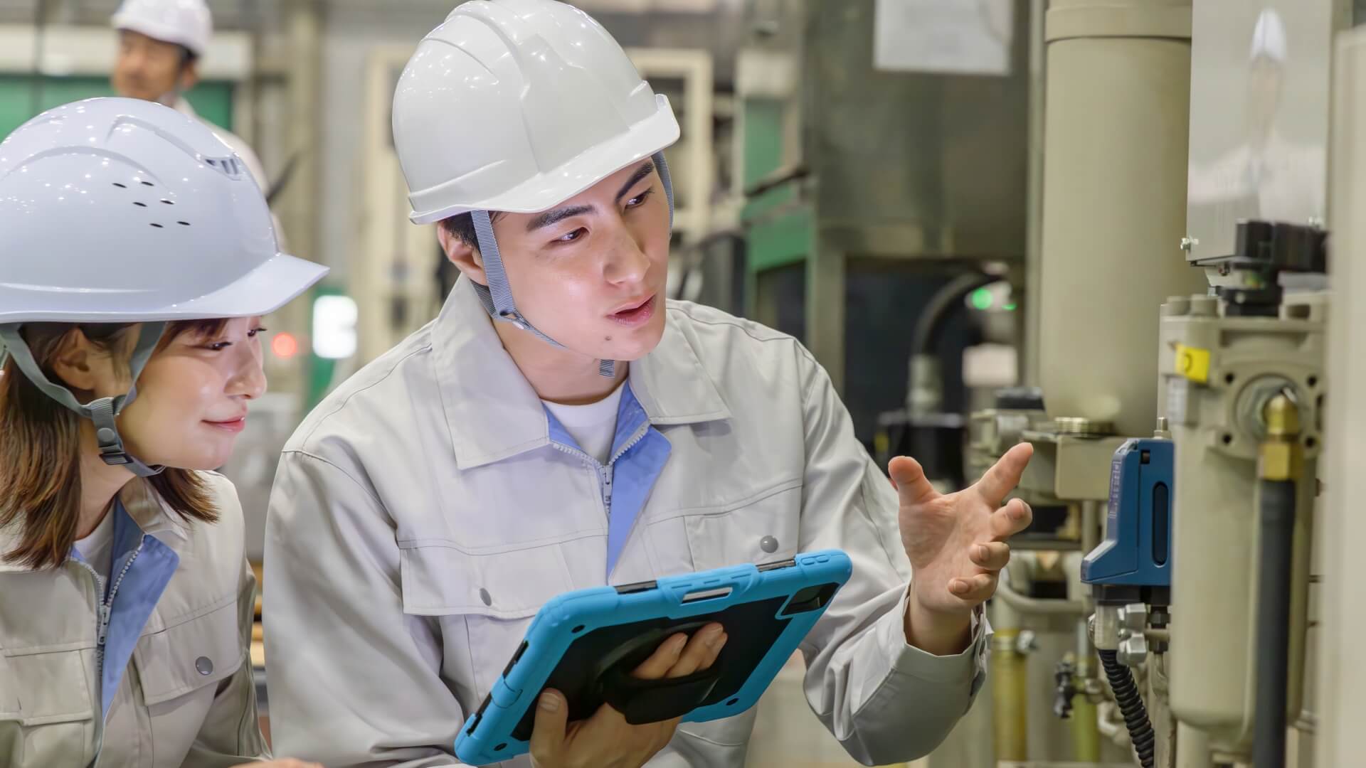 工場で会話しながらタブレット確認