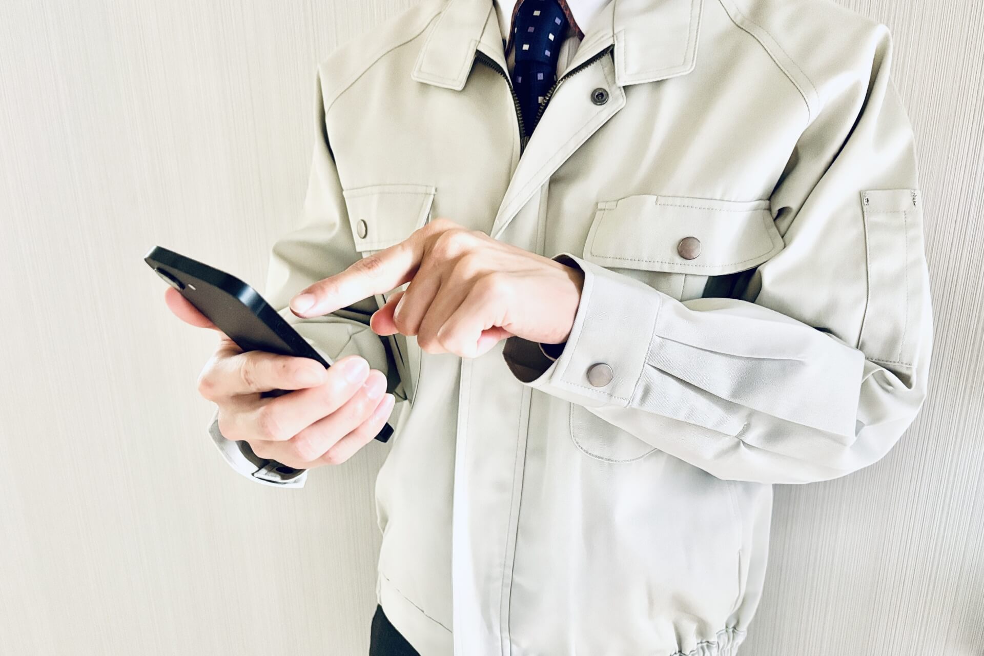 スマホ操作中の作業員の手元