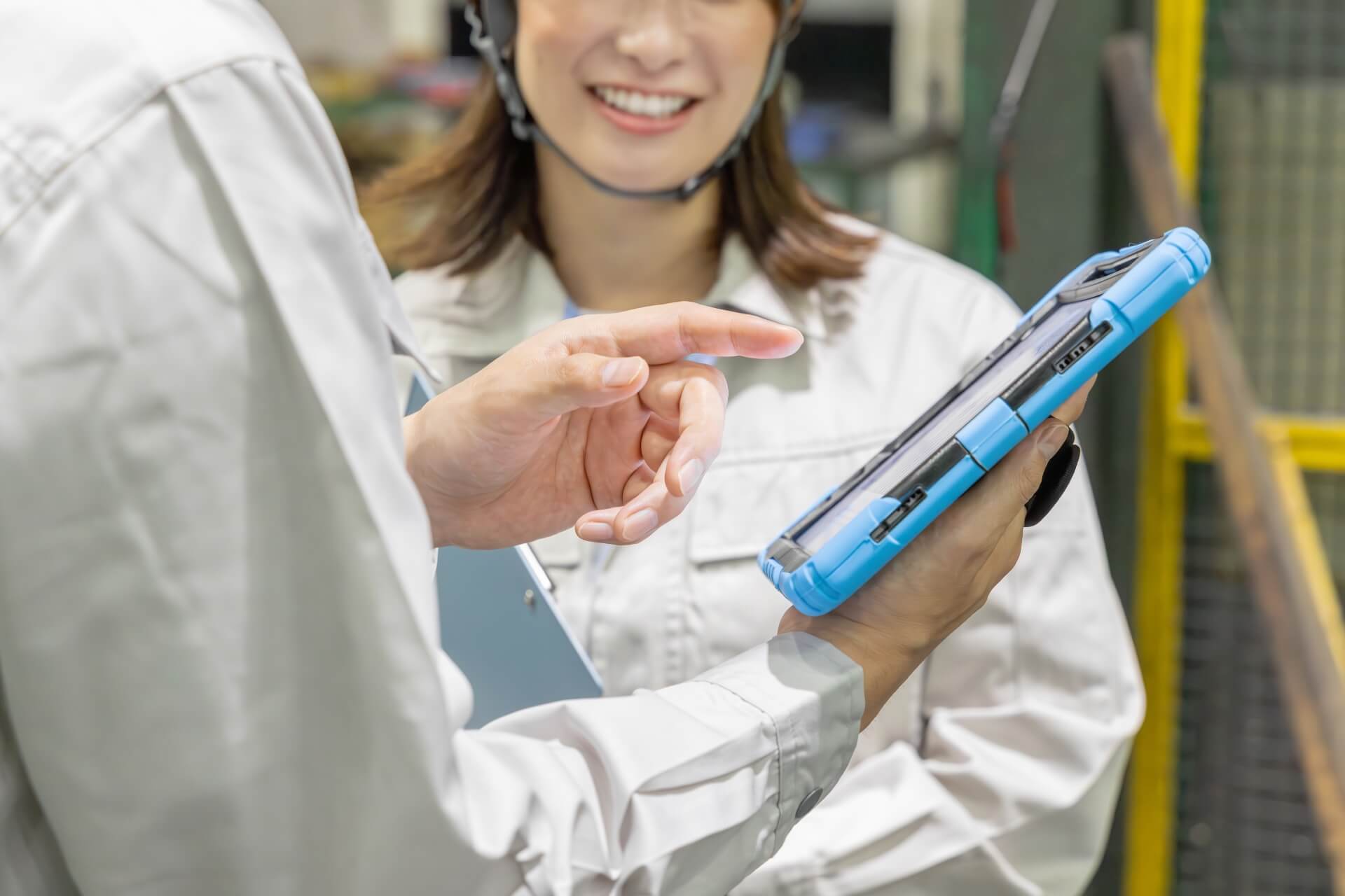 工場でタブレットを操作する女性作業員